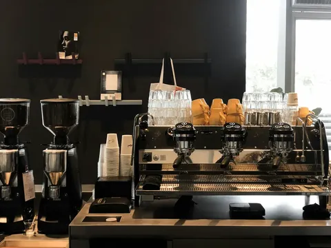 Commercial espresso machines and grinders lined up on a counter