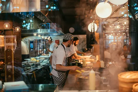 A commercial kitchen team cooking during a busy service