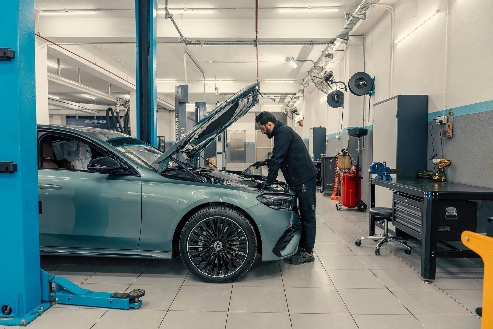 Vehicle technician working with professional garage equipment