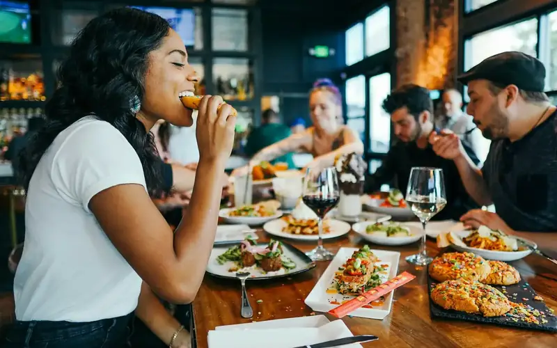 A busy restaurant with customers sharing food