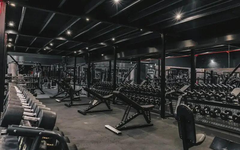 A gym floor with racks of weights and benches