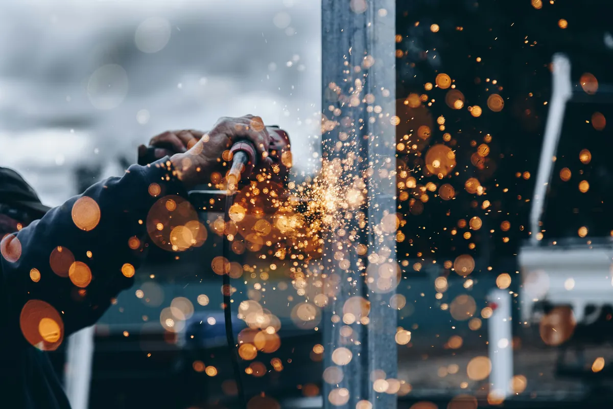 Fabrication worker using industrial metalworking equipment