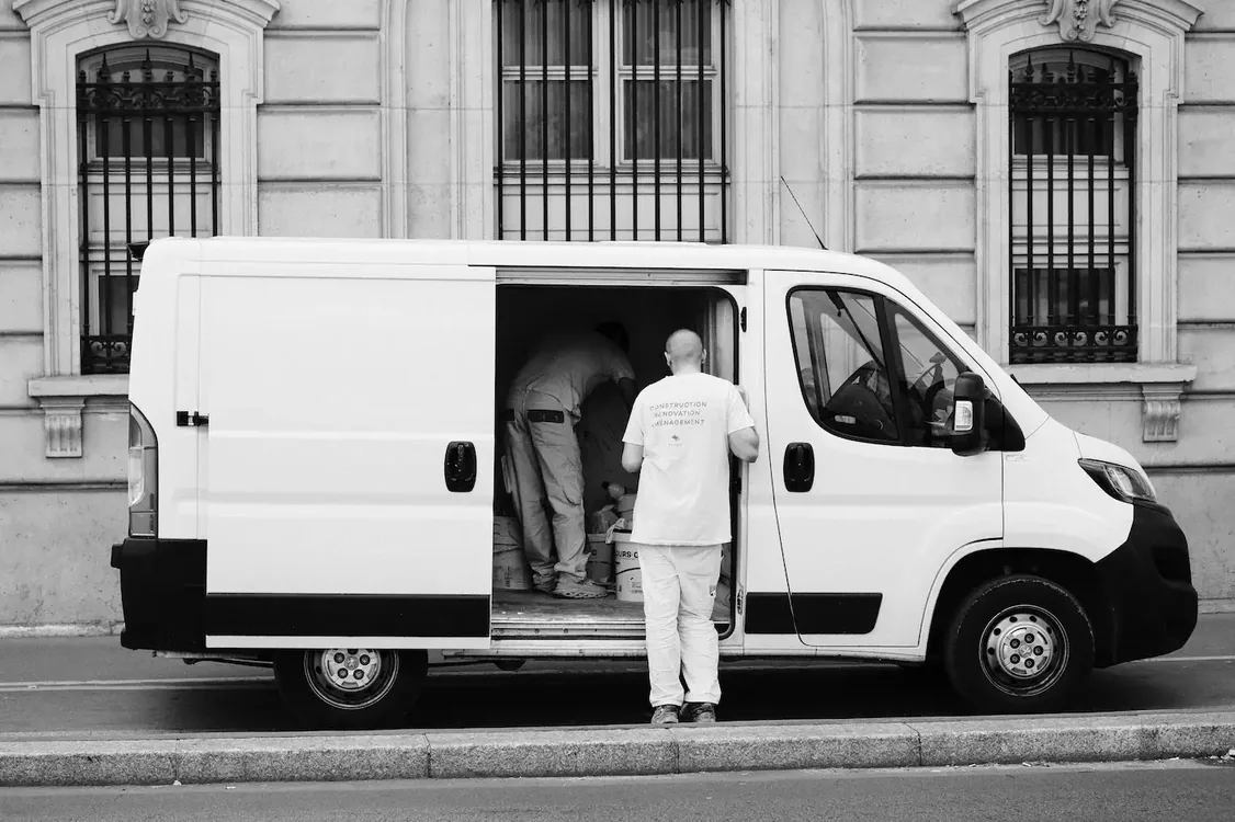 A commercial van being loaded at a city kerbside